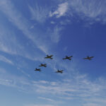 Spitfires and Hurricane fly over the airfield