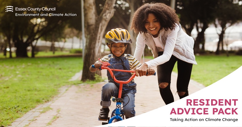 Woman helping her son who is riding a bike in the park