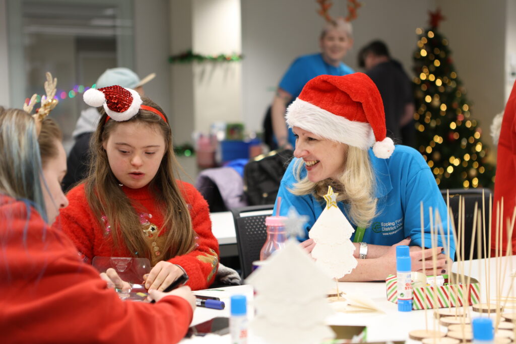 Staff member helping children create art at the arts and crafts table