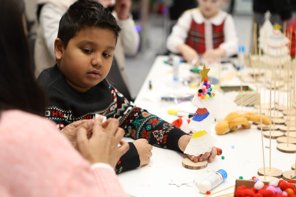 Child making art at the arts and crafts table