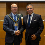 Chairman Les Burrows shaking hands with outgoing chairman Cllr Darshan Sunger
